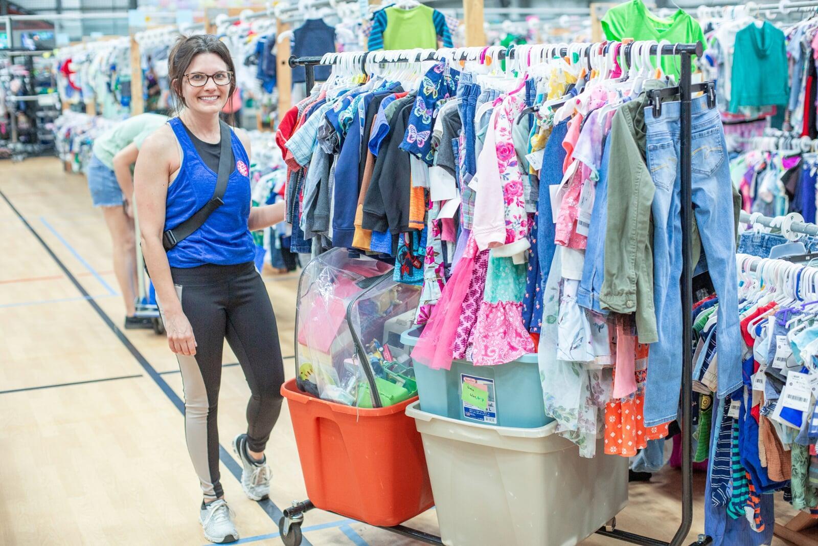 Two friends shop together—one mom wears her baby girl—as they find great deals at the JBF sale.